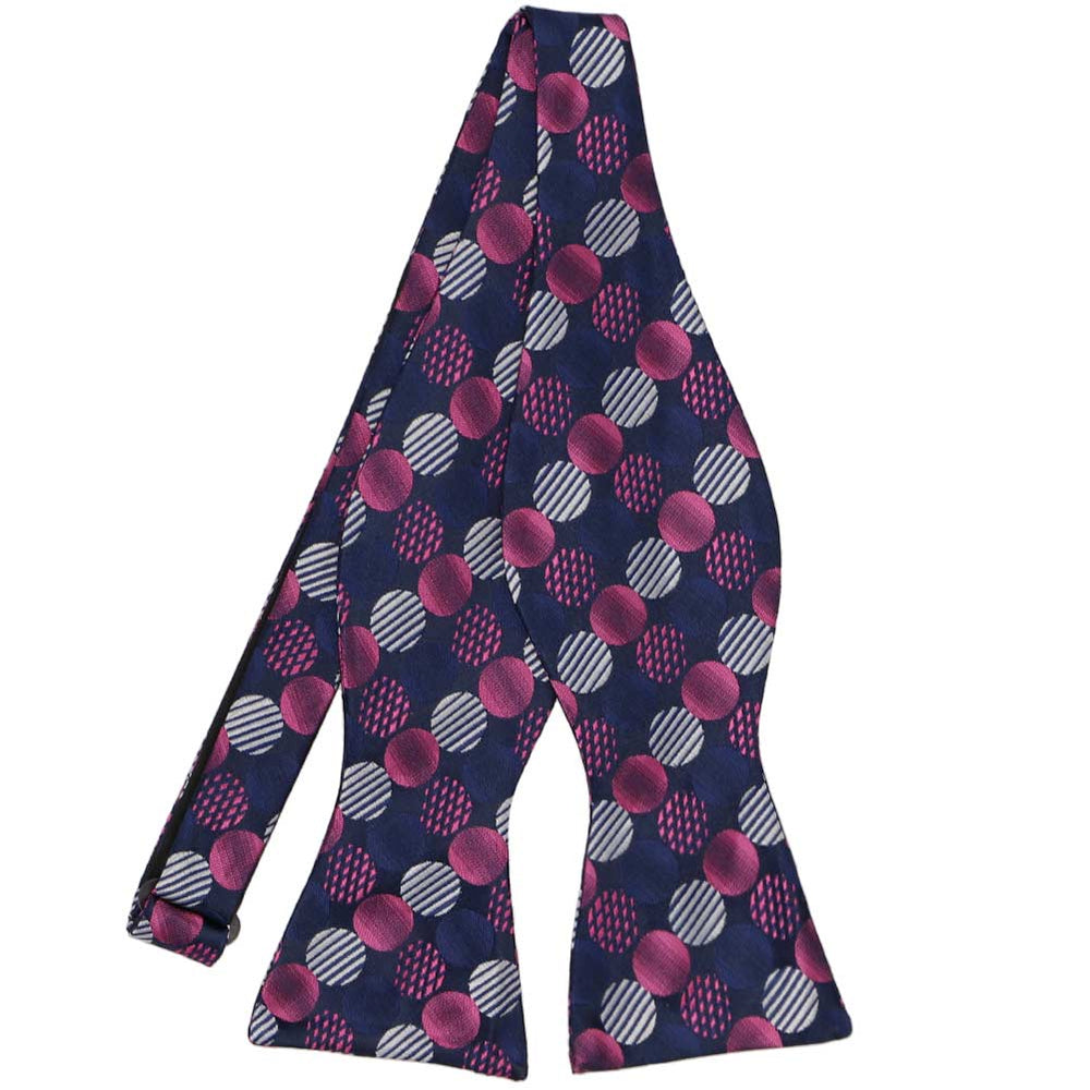 A pink and navy blue large dotted pattern self-tie bow tie, untied