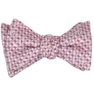A tied self-tie bow tie in a speckled pink plaid pattern