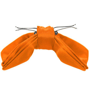 The side view of an opened pumpkin orange clip-on bow tie