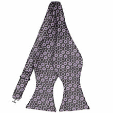 Load image into Gallery viewer, A purple and dark gray whimsical polka dot pattern self-tie bow tie. The polka dots have large and small gray dots in the middle.