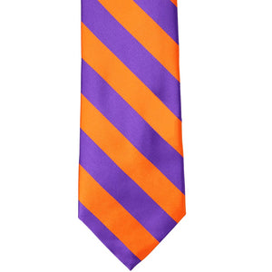 The front of an orange and purple striped tie, laid out flat