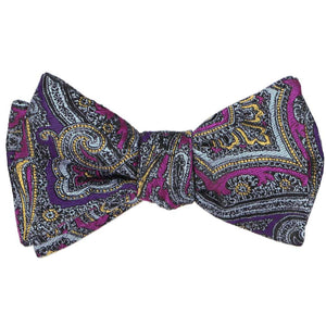 A tied self-tie bow tie in a detailed purple and light orange paisley pattern