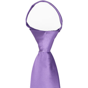 A closeup of a knot on a purple zipper tie