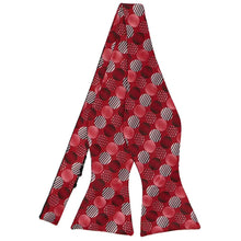 Load image into Gallery viewer, A self-tie bow tie, untied, in a large polka dot pattern 