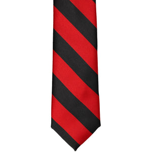 The front of a red and black striped tie, laid out flat