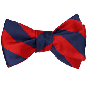 A red and navy blue striped self-tie bow tie, tied
