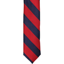 Load image into Gallery viewer, The front of a red and navy blue striped skinny tie, laid out flat
