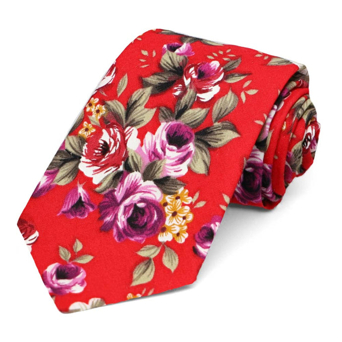 A red and purple floral tie, rolled to show off the tip
