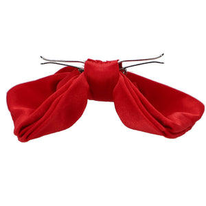 A red clip-on bow tie, opened and ready to attach to shirt