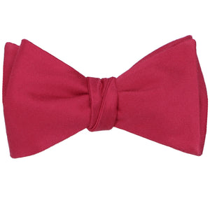 A tied red self-tie bow tie in a solid color