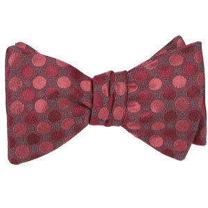 A tied self-tie bow tie in a crimson red tone-on-tone polka dot pattern