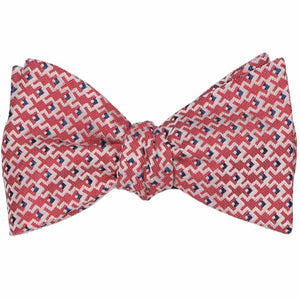 A tied self-tie bow tie in a red, white and blue geometric pattern