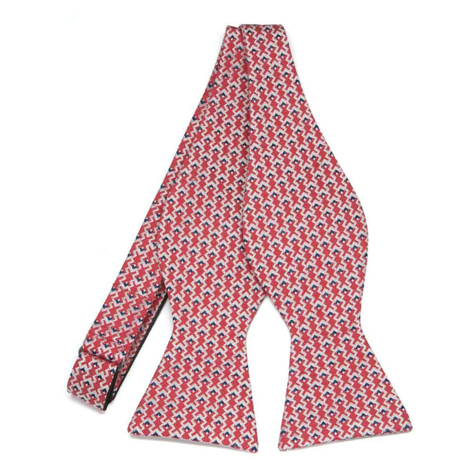 An untied red self-tie bow tie with white and blue zig zags