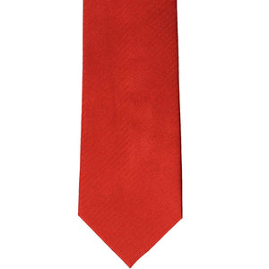 The front bottom view of a red herringbone silk tie