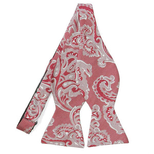 An untied red self-tie bow tie with large white paisley