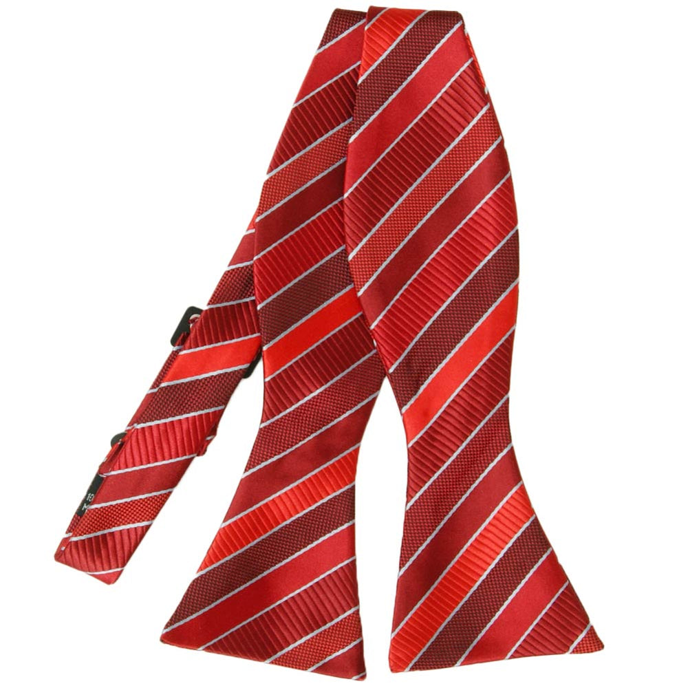 Flat front view of an untied red and silver striped self-tie bow tie