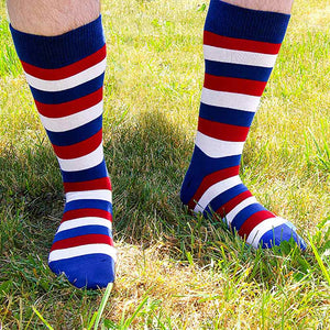 A man outside wearing a pair of red, white and blue striped socks