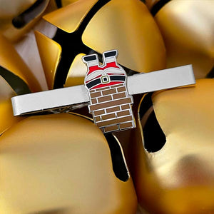 A Christmas-themed tie bar of Santa stuck in a chimney displayed with gold bells