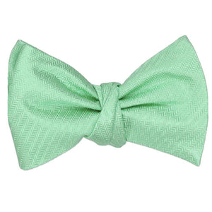 A tied herringbone self-tie bow tie in a tone on tone seafoam green