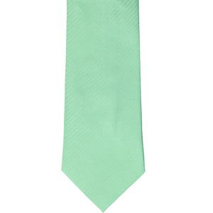 The front of a seafoam herringbone tie, laid out flat