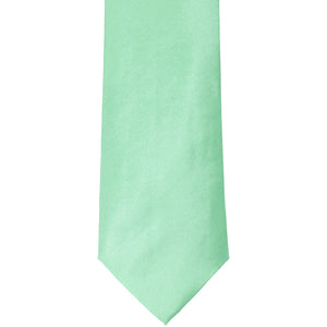 The front of a seafoam solid tie, laid out flat