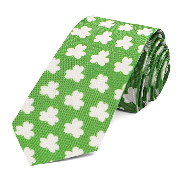 The front of a slim green tie with an all over white shamrock pattern, rolled to show off the design
