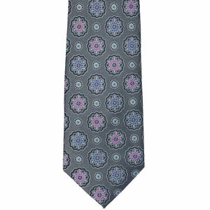 The front of a silver tie with floral medallions