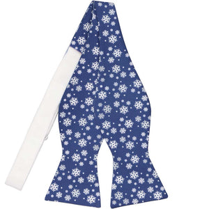 An untied self-tie bow tie with a blue and white snowflake pattern