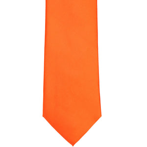 The front, bottom tip of a tangerine colored tie