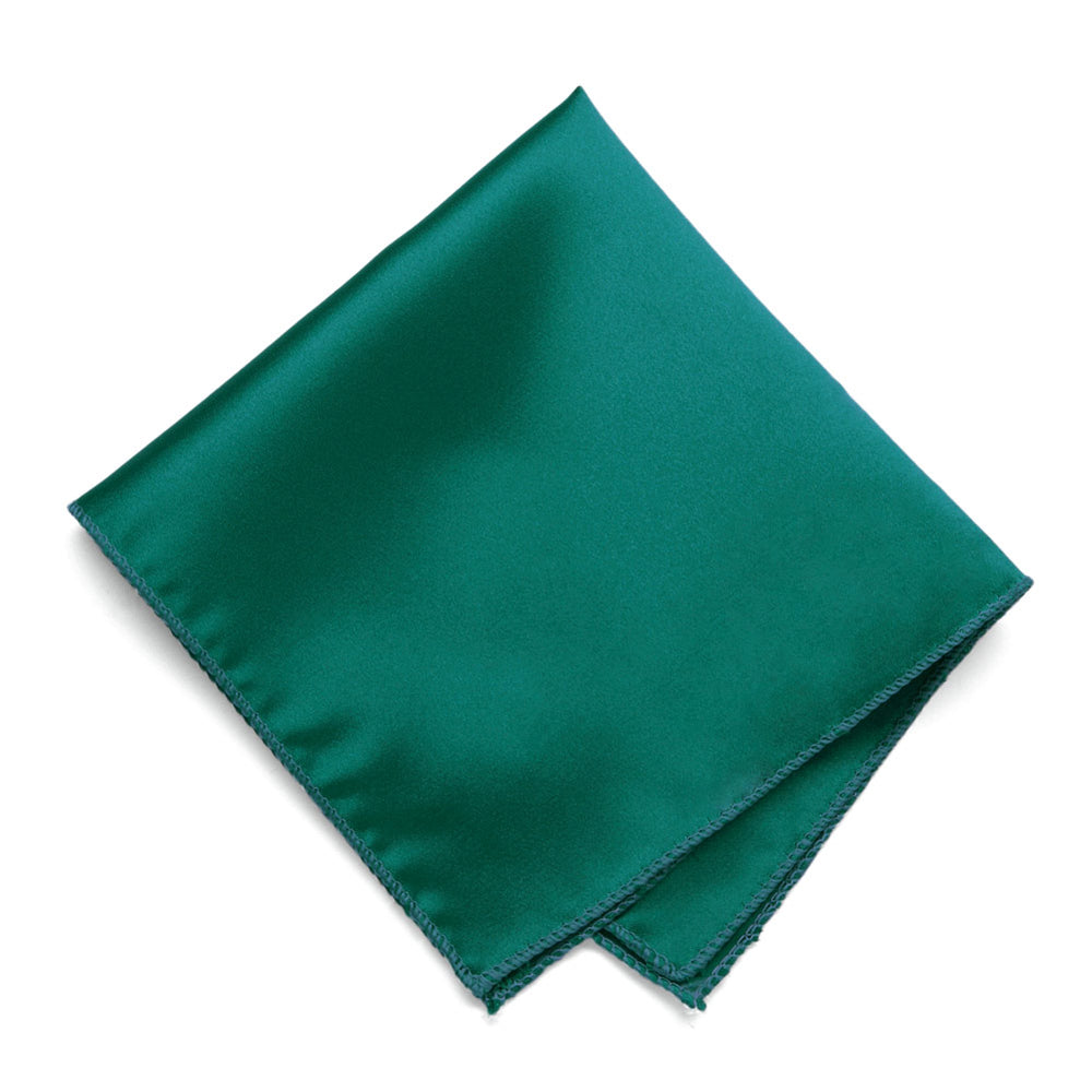 A teal pocket square, folded into a diamond shape