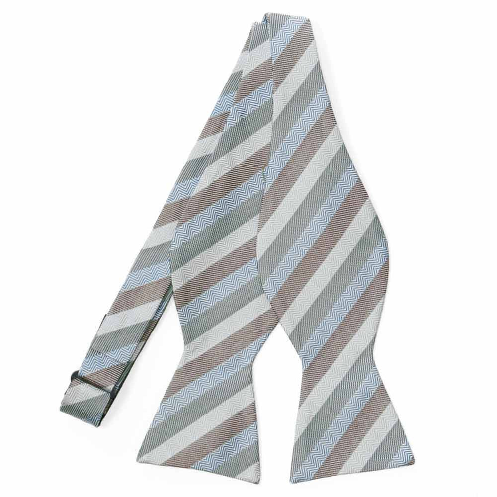 An untied self-tie bow tie in muted green blue brown and white stripes