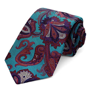 A turquoise and jewel-toned paisley necktie, rolled to show off the pattern