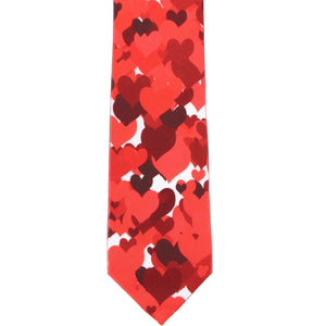 The front, flat view of a slim tie with a scattered red heart pattern